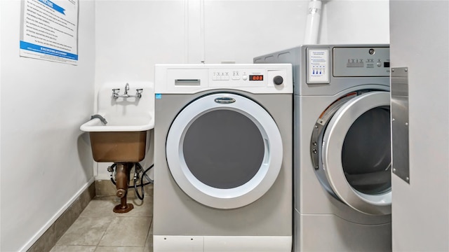 laundry area with light tile patterned floors and washing machine and dryer