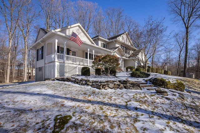 view of snowy exterior featuring covered porch