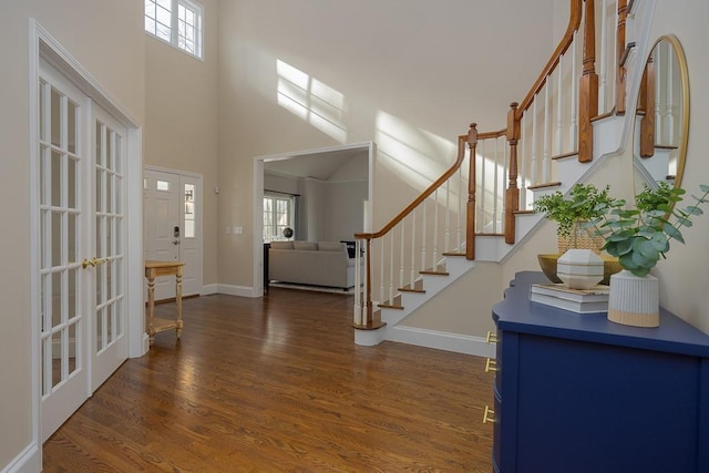 foyer entrance featuring dark hardwood / wood-style flooring, plenty of natural light, a high ceiling, and french doors