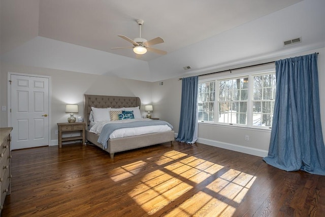 bedroom featuring a raised ceiling, ceiling fan, and dark hardwood / wood-style flooring