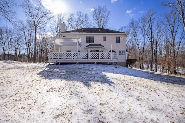 snow covered property with a pergola and a wooden deck