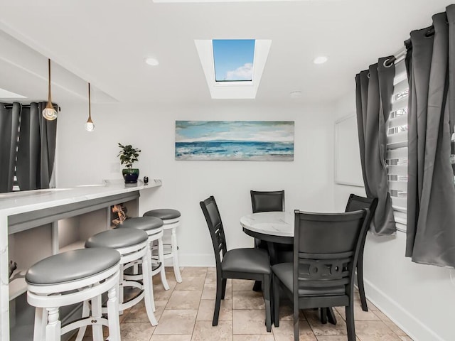 dining space with baseboards, a skylight, recessed lighting, and light tile patterned floors