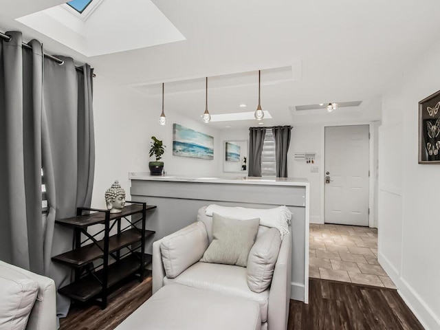 living room featuring a skylight, baseboards, and dark wood finished floors