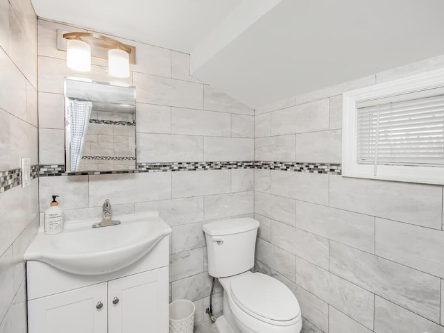 bathroom with tile walls, toilet, and vanity