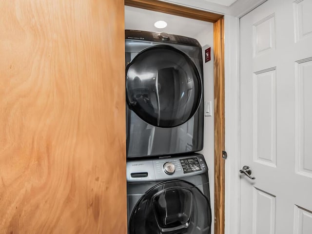 clothes washing area with stacked washer / dryer and laundry area