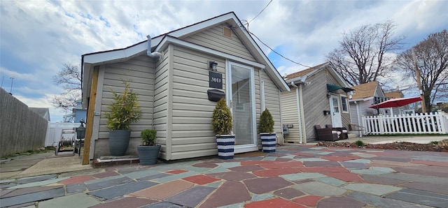 rear view of property featuring entry steps, fence, and a patio area