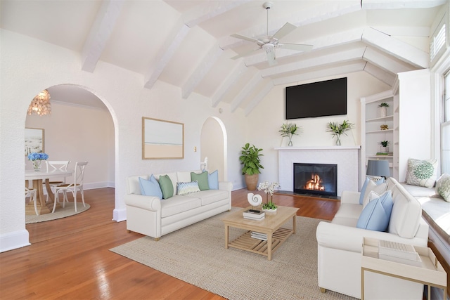 living room with hardwood / wood-style flooring, ceiling fan, and vaulted ceiling with beams