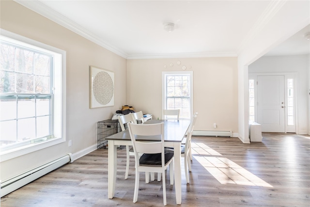 dining room with ornamental molding, light hardwood / wood-style floors, and baseboard heating