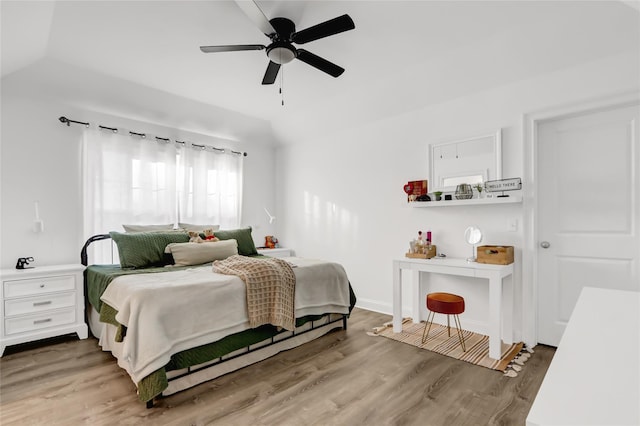 bedroom with hardwood / wood-style floors, vaulted ceiling, and ceiling fan