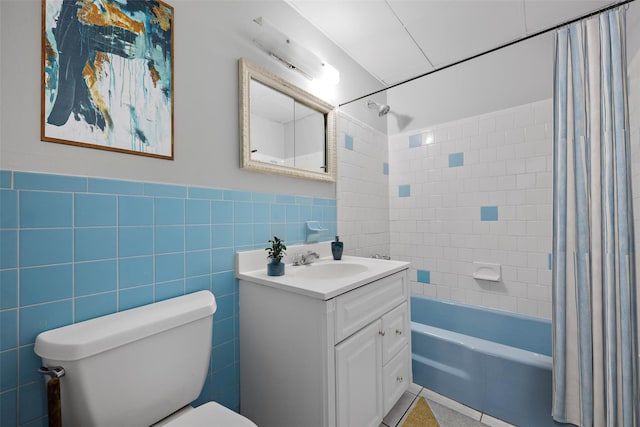 full bathroom with shower / bath combination with curtain, vanity, toilet, and tile walls