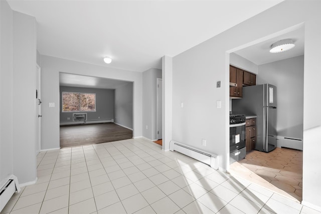 kitchen with stainless steel appliances, light tile patterned floors, and a baseboard heating unit