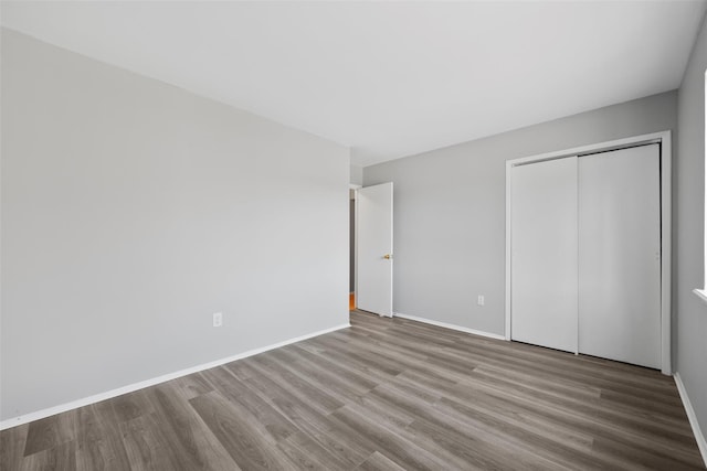 unfurnished bedroom with light hardwood / wood-style floors and a closet