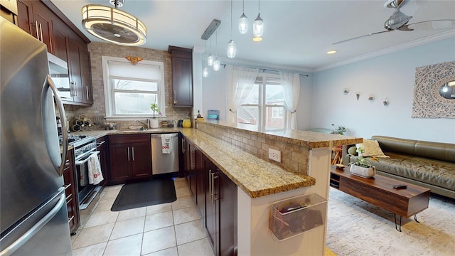 kitchen with appliances with stainless steel finishes, decorative light fixtures, backsplash, ornamental molding, and kitchen peninsula