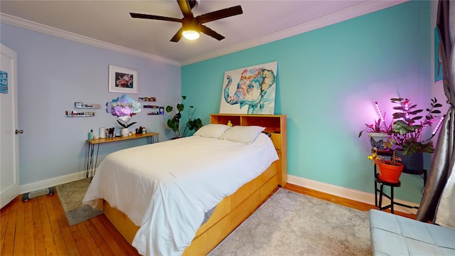 bedroom featuring ornamental molding, wood-type flooring, and ceiling fan