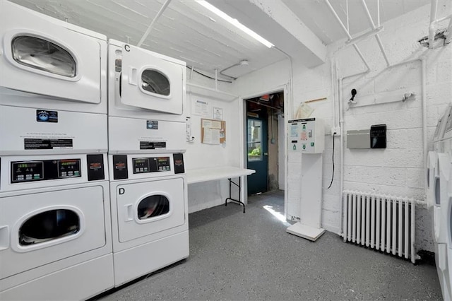 washroom with separate washer and dryer, radiator, and stacked washing maching and dryer