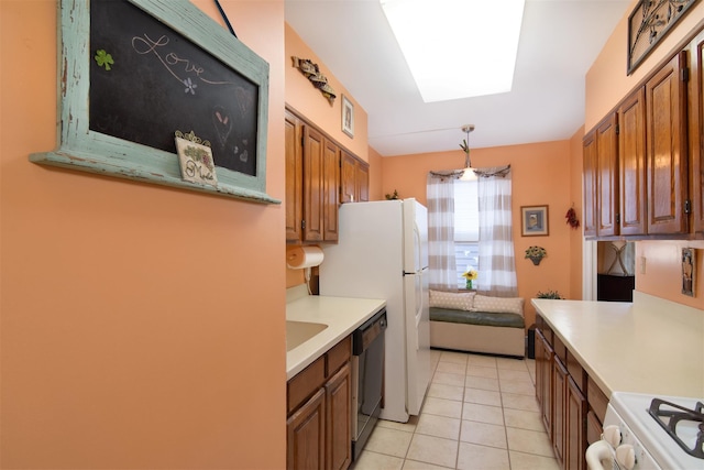 kitchen featuring lofted ceiling with skylight, white gas stove, light tile patterned floors, black dishwasher, and pendant lighting