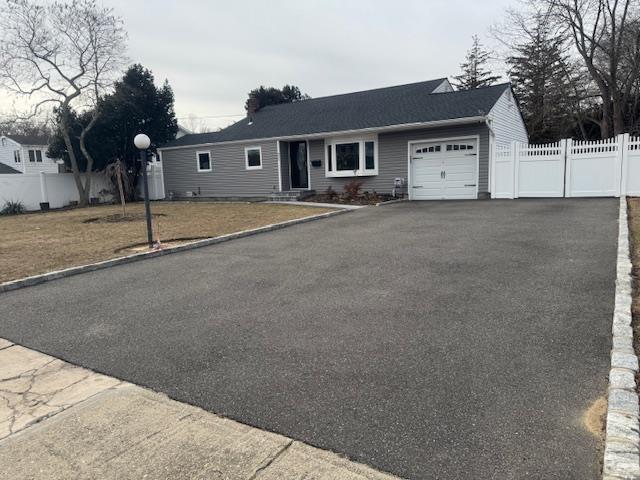 single story home with a garage and a front yard