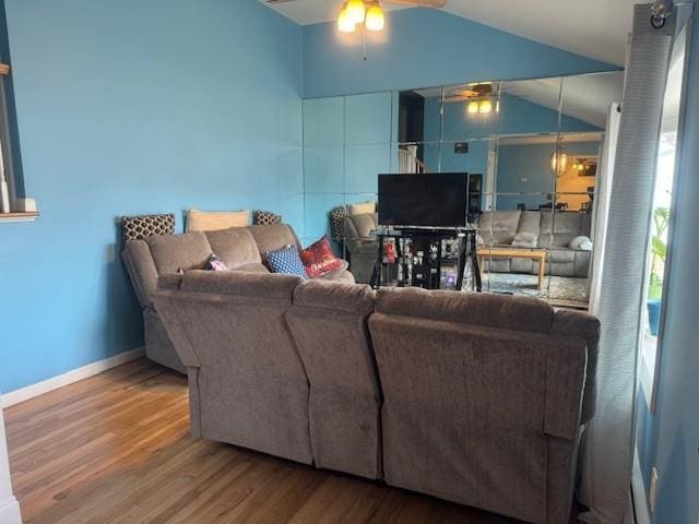 living room with wood-type flooring, ceiling fan, and vaulted ceiling