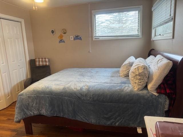 bedroom featuring a closet, hardwood / wood-style floors, and multiple windows