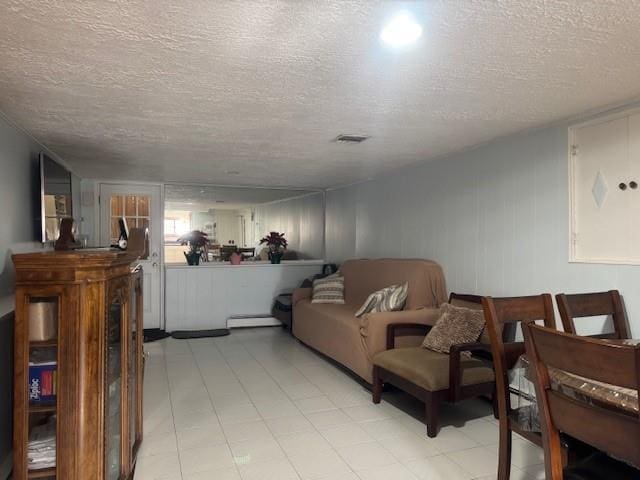 living room featuring a textured ceiling and baseboard heating