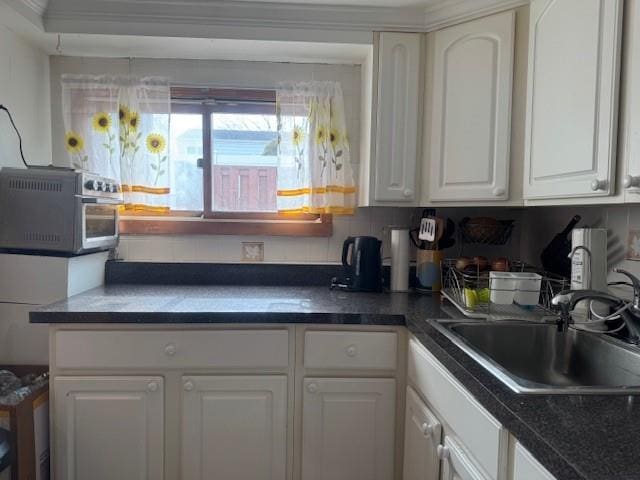 kitchen featuring sink and white cabinets