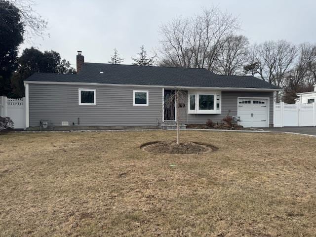 single story home featuring a garage and a front lawn