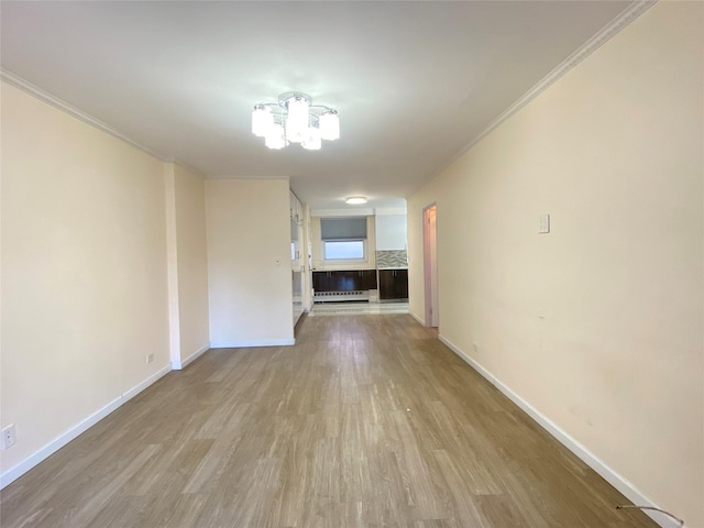 interior space with crown molding, baseboard heating, and light hardwood / wood-style floors