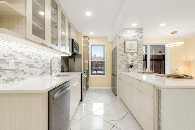 kitchen with stainless steel appliances, sink, and decorative backsplash