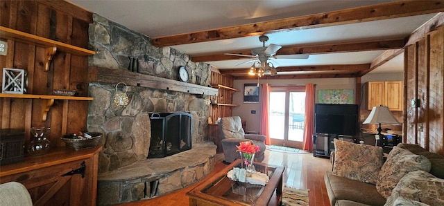 581 Hessinger Lare Rd, Jeffersonville, NY 12748 - living room with wood finished floors, a stone fireplace, a ceiling fan, and beamed ceiling