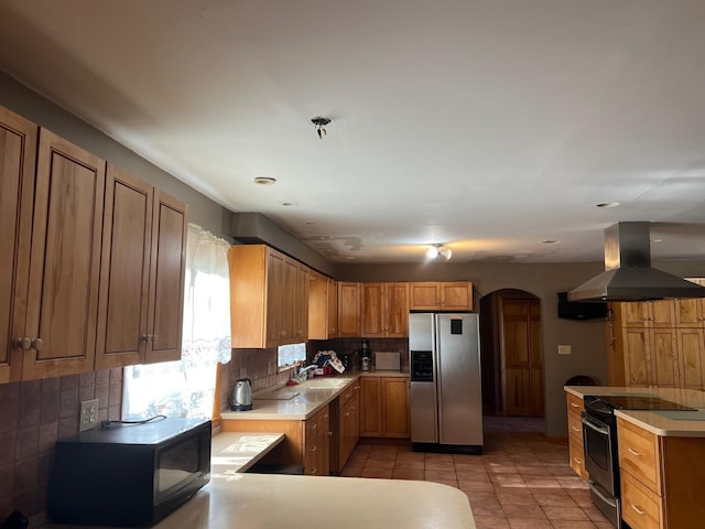 581 Hessinger Lare Rd, Jeffersonville, NY 12748 - kitchen featuring appliances with stainless steel finishes, range hood, arched walkways, decorative backsplash, and light tile patterned floors