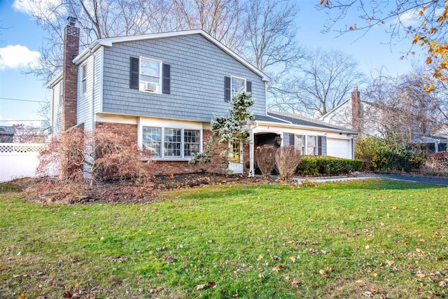 view of front facade with a garage, brick siding, a front lawn, and a chimney