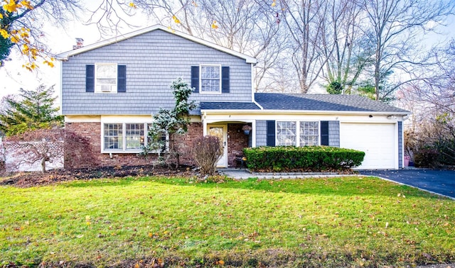 view of front facade with driveway, brick siding, a front lawn, and an attached garage