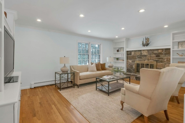 living room with light hardwood / wood-style flooring, baseboard heating, ornamental molding, built in features, and a fireplace