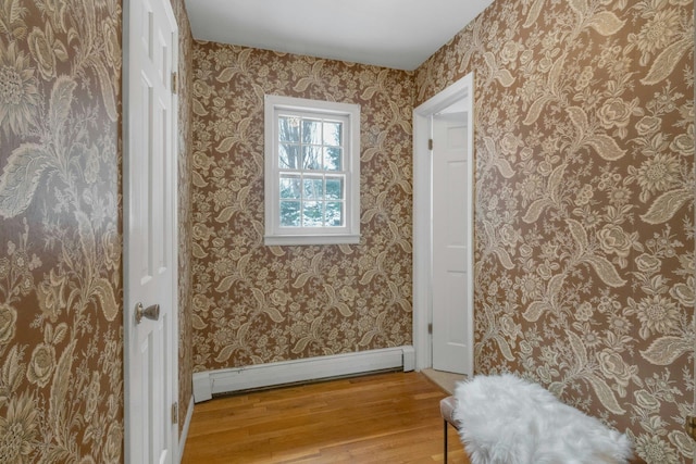 doorway featuring wood-type flooring and a baseboard heating unit