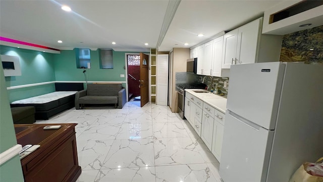 kitchen with white cabinetry, ornamental molding, white fridge, high end stainless steel range oven, and backsplash