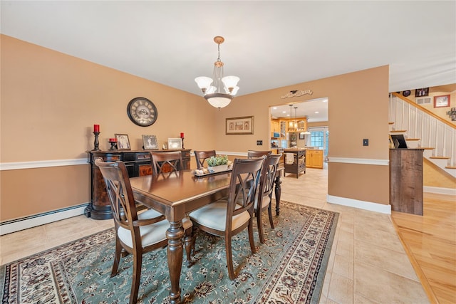 dining room with an inviting chandelier, a baseboard heating unit, and light tile patterned flooring