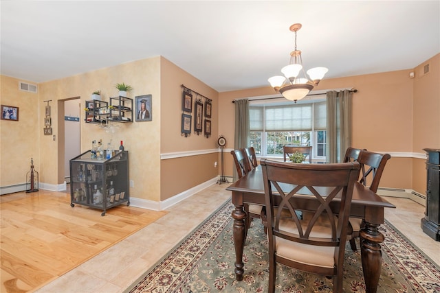 dining area with a baseboard heating unit, a notable chandelier, and light wood-type flooring