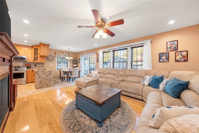 living room with ceiling fan and light hardwood / wood-style flooring