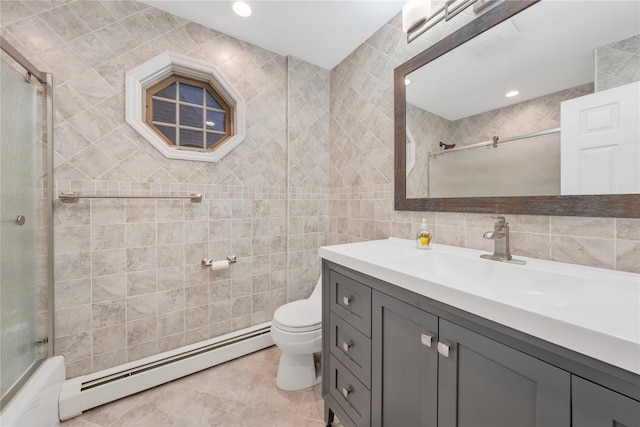 full bathroom with a baseboard radiator, tile walls, enclosed tub / shower combo, vanity, and toilet