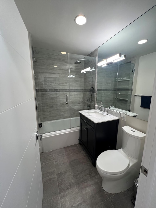 full bathroom with vanity, combined bath / shower with glass door, and toilet