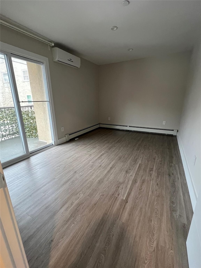 spare room with wood-type flooring and a wall mounted air conditioner