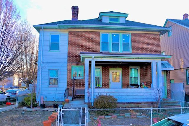 view of front of house with brick siding, a chimney, and a fenced front yard