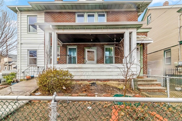 view of front of property featuring brick siding and a fenced front yard