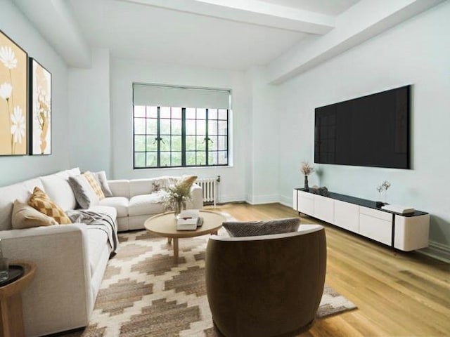 living room featuring radiator heating unit, beamed ceiling, and light wood-type flooring