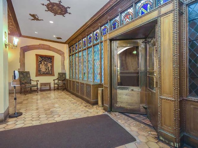 hall with ornamental molding and light tile patterned flooring