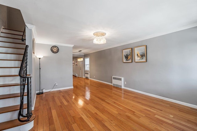 interior space featuring ornamental molding, radiator, an inviting chandelier, and light hardwood / wood-style floors