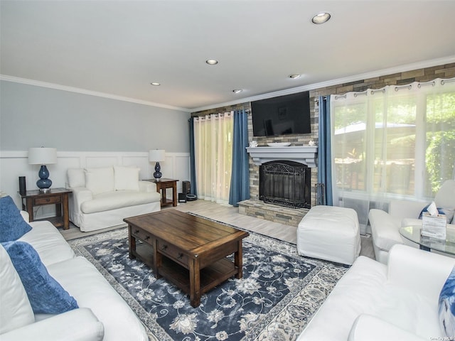 living room with crown molding, wood-type flooring, and a fireplace