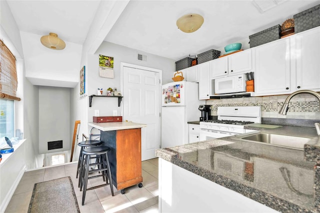192 Bch 74th St, Arverne, NY 11692 - kitchen with white appliances, a sink, backsplash, white cabinets, and beam ceiling