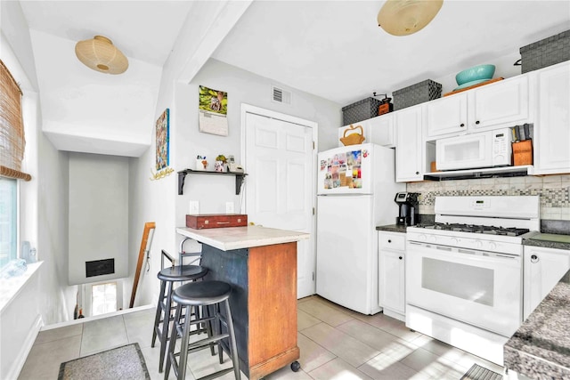192 Bch 74th St, Arverne, NY 11692 - kitchen featuring white appliances, white cabinetry, decorative backsplash, and a kitchen breakfast bar