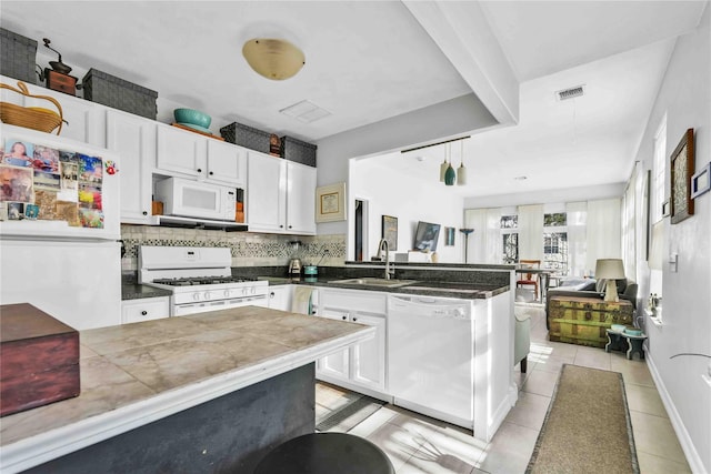 192 Bch 74th St, Arverne, NY 11692 - kitchen featuring white appliances, a peninsula, a sink, and white cabinetry